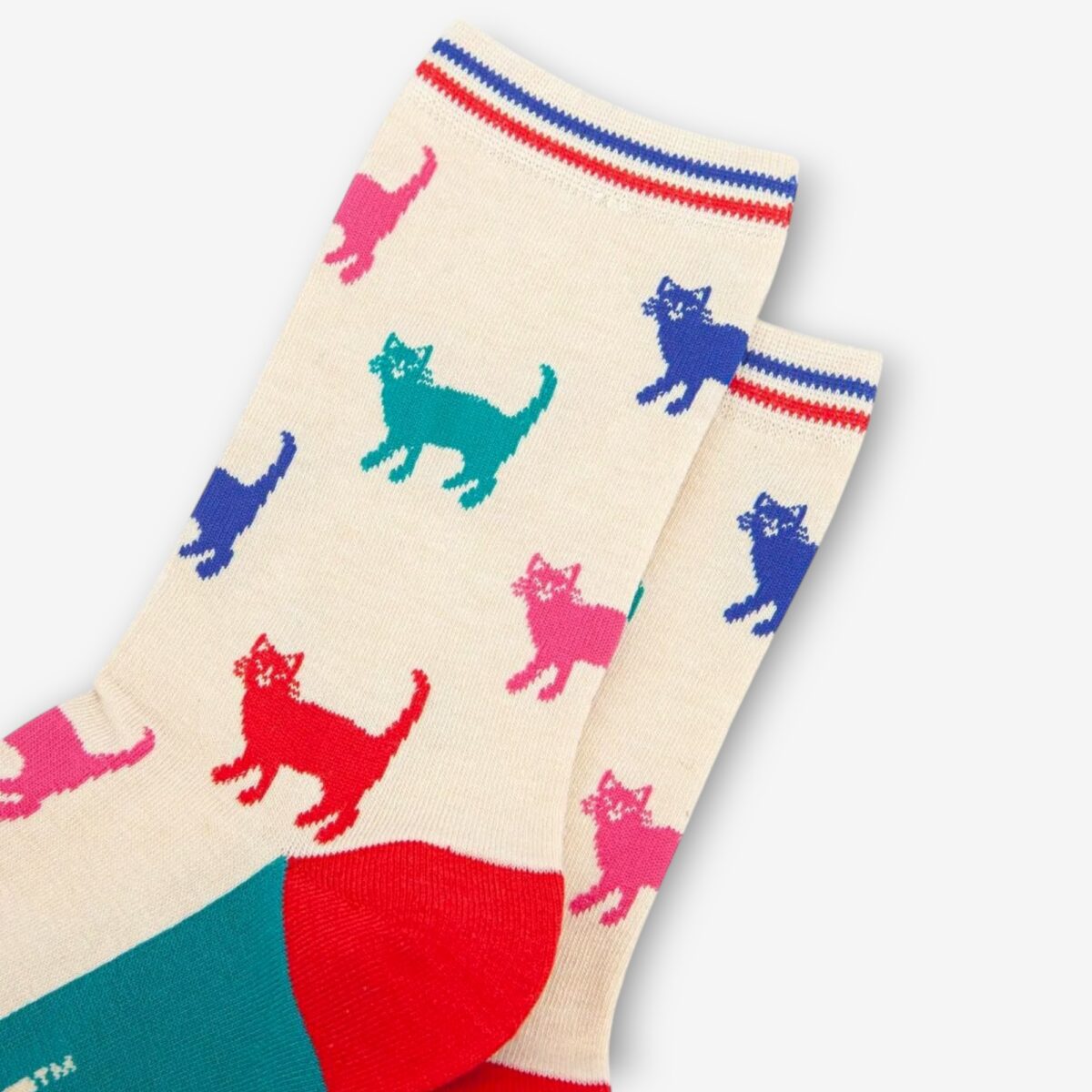 Detailed angled shot of cream socks with colorful cat print, highlighting red toe and teal heel